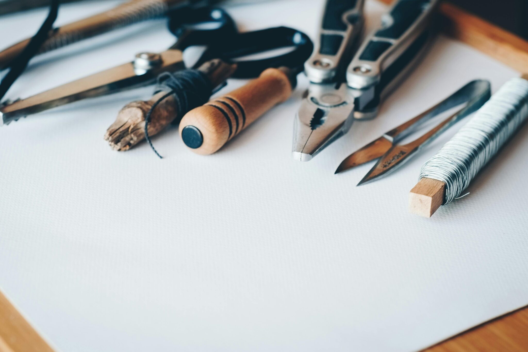 A selection of artisan tools and handmade crafts displayed on a white desk, perfect for creative projects.